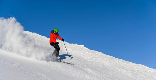 Skier descending steep slope