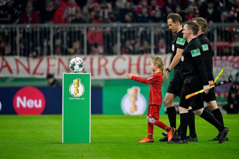 Ball child ball girl runs with outstretched arms towards the ball