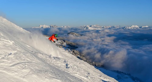 Female skier descending steep slope