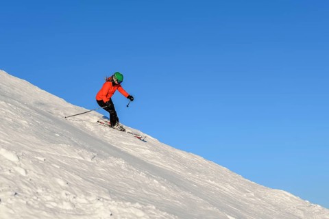 Female skier descending steep slope
