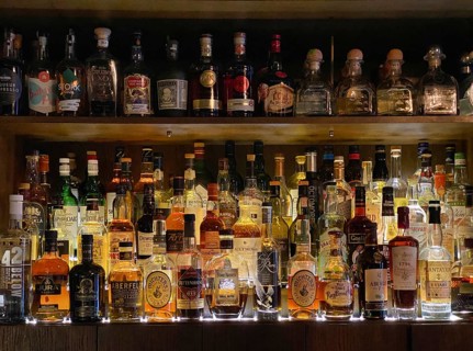 Various whiskey bottles and gin bottles in a bar