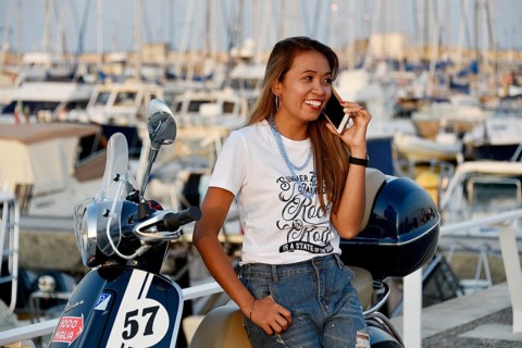 Woman with Vespa 125 Primavera in the port of Penelope