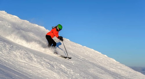 Female skier descending steep slope
