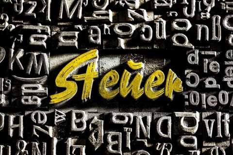 Old lead letters with golden writing show the word tax
