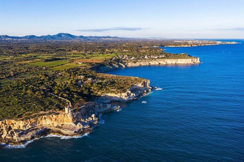 Steep coast with watchtower Torre d'en Beu near Cala Figuera