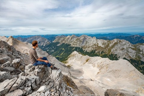 Hiker sitting at the summit of the Birkkarspitze
