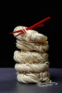 Stacked Asian nest noodles and red chopsticks