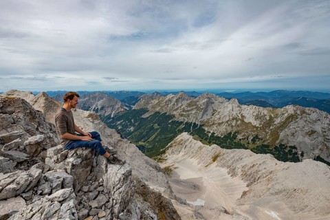 Hiker sitting at the summit of the Birkkarspitze