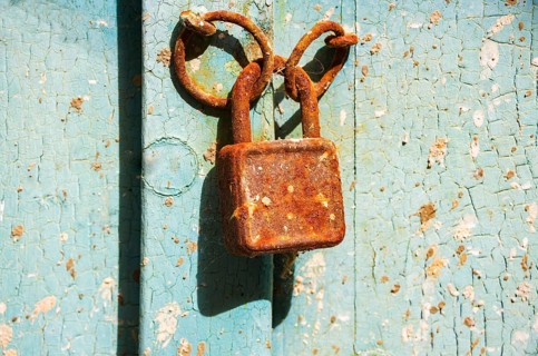 Old rusty door lock on weathered wooden door