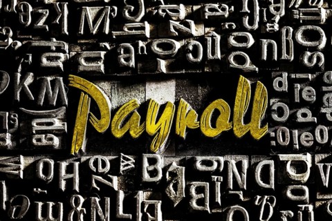 Old lead letters with golden writing show the word Payroll