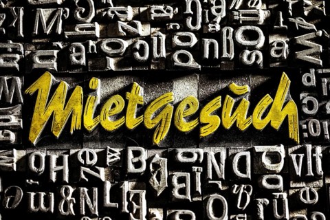 Old lead letters with golden writing show the word Mietgesuch