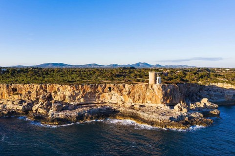 Steep coast with watchtower Torre d'en Beu near Cala Figuera