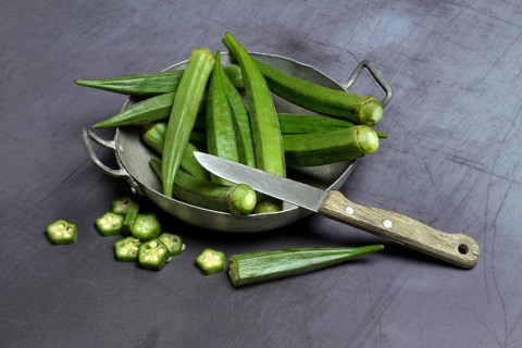 Okras in bowl and kitchen knife