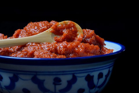 Red Thai curry paste with spoon in bowl