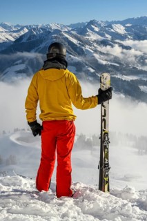 Skier standing at the ski slope holding ski