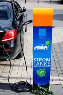 Electric car fills up on green electricity at a power charging station