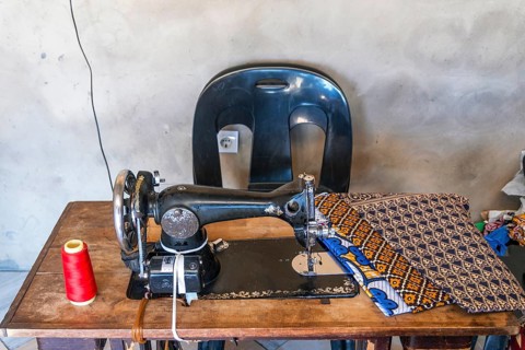 Sewing machine and African fabrics in seamstress workshop