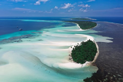 Uninhabited chain of islands with a wide sandbank on the eastern outer reef