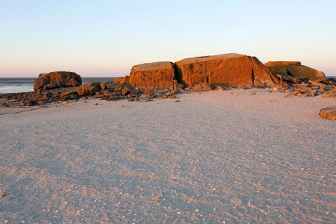 Bunker remains of an anti-aircraft gun position from World War II on the Minsener Oog power station in the evening light