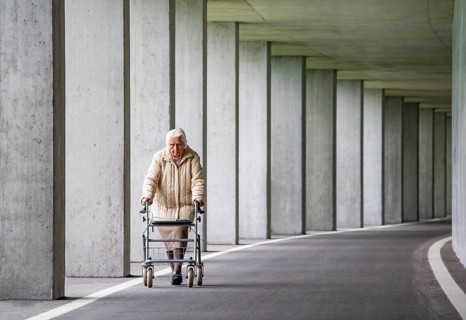 Senior citizen with walker walks in an underpass