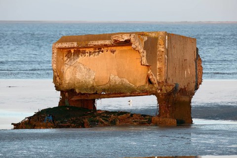 Bunker remains of an anti-aircraft gun position from World War II on the Minsener Oog power station in the evening light