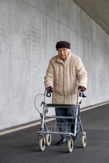 Senior citizen with walker walks in an underpass