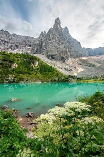 Turquoise-green Sorapis lake with flowers