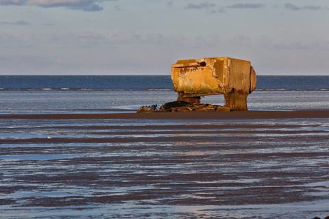 Bunker remains of an anti-aircraft gun position from World War II on the Minsener Oog power station in the evening light