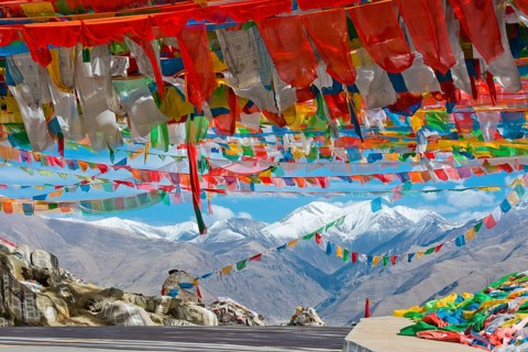 Pass road with Buddhist prayer flags at the Nachan La Pass (4500 m) above the Kyichu Valley