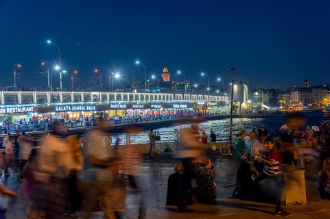 People in front of the Galata Bridge at night