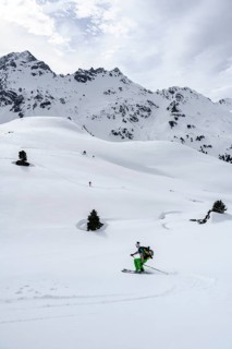 Ski tourers on the descent in deep snow