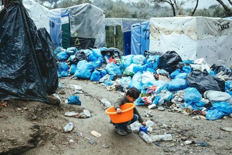 Child collects utensils from the garbage in the refugee camp in Moria