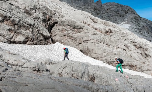 Female mountaineers on marked route through rocky alpine terrain