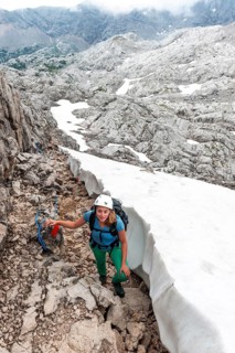 Mountaineer on secured route next to snow field from Simonyhuette to Adamekhuette