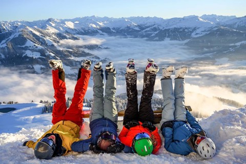 Skiers lie in the snow and stretch their legs in the air