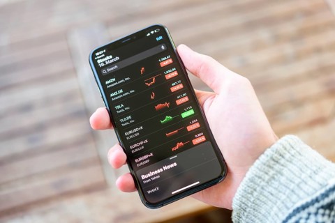 Hand holds iPhone 11 with stock app on display