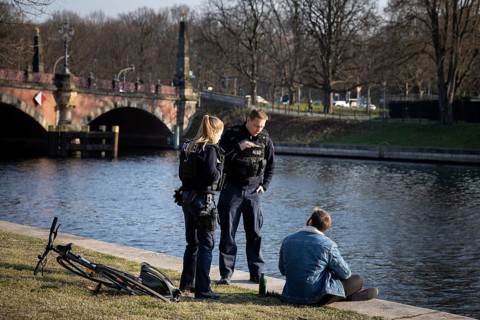 Policemen admonish passers-by on the banks of the Spree