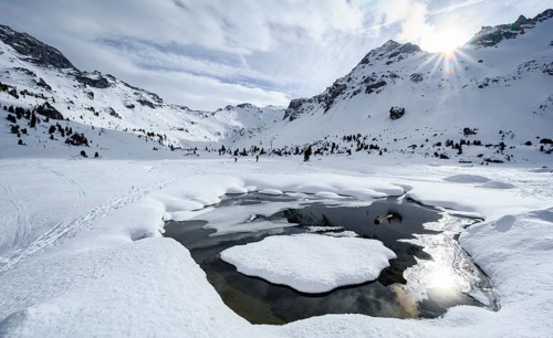 Sun shines over snow-covered mountain peaks