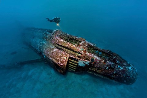 Diver looks at airplane wreck