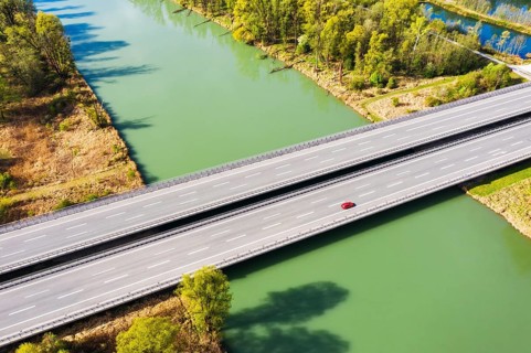 Lonely red car on motorway bridge of the motorway A8 over the river Inn