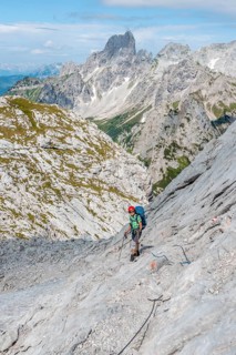 Hiker on a rocky route secured with a wire rope from Simonyhuette to Adamekhuette