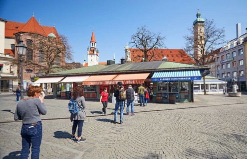 Queue of people with a safe distance in front of food stalls at Viktualienmarkt