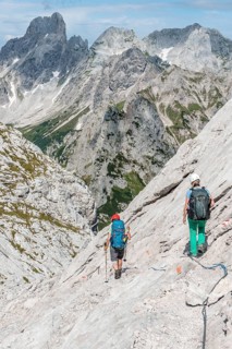 Hiker on a rocky route secured with a wire rope from Simonyhuette to Adamekhuette