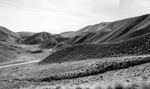 Black and white photo, barren mountain landscape with pass road
