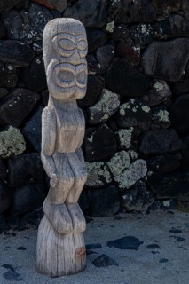 Guardian wooden tiki in front of big wall, Pu'uhonua O Honaunau National Historical Park