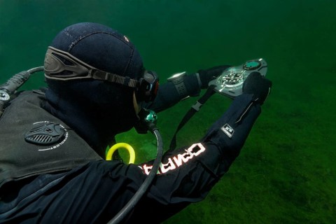 Divers in dry suits orientate themselves with compass in waters with poor visibility, Echinger Weiher