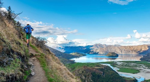 Hiker on the hiking trail to Rocky Peak, views of Wanaka Lake and mountains