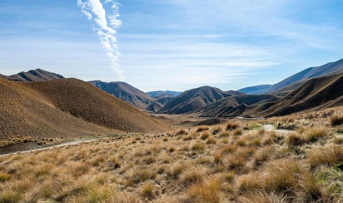 Barren mountain landscape with tufts of grass, Lindis Pass