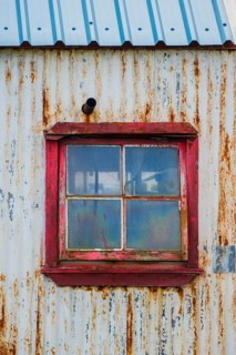 Rusty, weathered corrugated iron facade with window