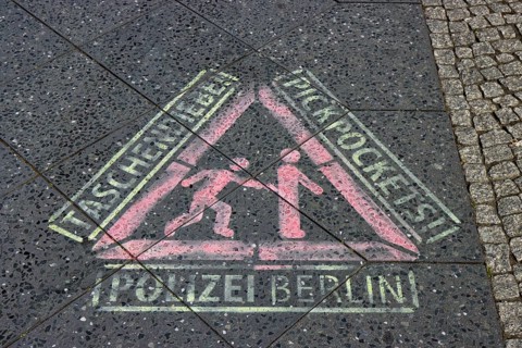 Sprayed stencil, police warning against pickpockets in German and English